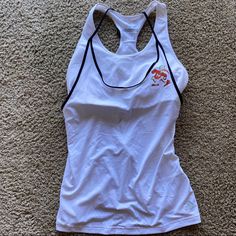 a woman's white tank top laying on the floor