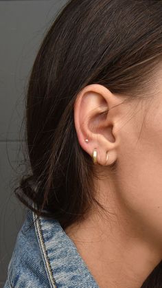 a close up of a person's ear with an earring in the middle