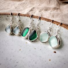 These handmade silver earrings are made with genuine Seaham sea glass from the North East of England in the UK. They come in a variety of colours, from delicate seafood blue to gorgeous teal green.  Size of sea glass: approx. 12-15 mm Drop length: approx. 25-28 mm The pieces of sea glass have been hand-selected and delicately arranged into matching pairs of shape and colour before being bezel set in recycled 925 sterling silver and attached to simple sterling silver ear wires. These earrings mak Silver Sea Glass Drop Earrings, Silver Sea Glass Earrings For Gift, Silver Sea Glass Dangle Earrings, Beach Earrings In Silver With Recycled Glass, Beach Silver Earrings With Recycled Glass, Silver Recycled Glass Beach Earrings, Silver Recycled Glass Earrings For The Beach, Handmade Silver Sea Glass Earrings, Handmade Silver Earrings With Sea Glass