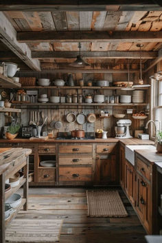 an old fashioned kitchen with wooden cabinets and shelves filled with pots, pans, and other items