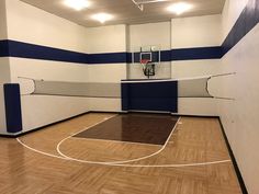 an indoor basketball court with blue and white stripes on the walls is pictured in this image