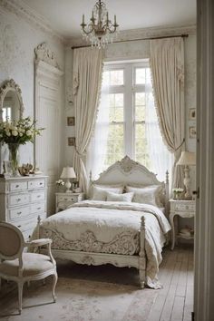 a white bed sitting in a bedroom next to a window with drapes on it