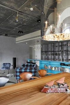 an open concept living room and dining area with wood flooring, blue cabinets and chairs