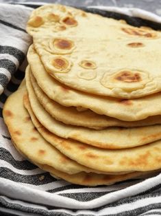 a stack of pita bread sitting on top of a black and white striped towel