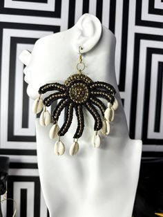 These statement pieces feature a radiant gold-tone filigree in a mesmerizing spiral and leaf design, reminiscent of a stylized sun. Bohemian Sun Design Jewelry For Beach, Beach Jewelry With Gold And Black Beads, Gold Bohemian Jewelry With Black Beads, Bohemian Gold Jewelry With Black Beads, Elegant Black Beads Beach Jewelry, Gold Jewelry With Black Beads For The Beach, Elegant Beach Jewelry With Black Beads, Elegant Black Beads Jewelry For Beach, Stylized Sun