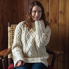 a woman sitting in a chair wearing a sweater