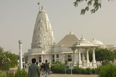 people walking in front of an ornate white building