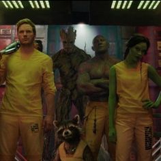 a group of people in yellow outfits standing next to each other with a raccoon