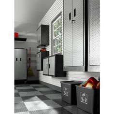 a kitchen with black and white checkered flooring, stainless steel cabinets and storage bins