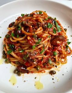 pasta with olives and sauce on a white plate