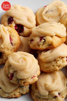 a white plate topped with cookies covered in frosting and cranberry toppings