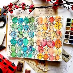 an art journal with watercolors, stamps and other things on top of it