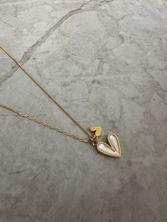 The double heart necklace features a white pearlescent heart and a little gold heart next to it. Perfect for gifting! Measurements: Height: 1.1cmWidth: 1.3 cm White Initial Pendant Necklace With Delicate Chain, White Initial Pendant Charm Necklace With Delicate Chain, White Necklace With Pearl And Initial Pendant, White Pearl Pendant Necklace With Initial, Everyday White Heart Charm Necklaces, White Heart-shaped Minimalist Jewelry, Everyday White Heart Charm Necklace, Minimalist White Heart-shaped Jewelry, White Heart Charm Jewelry For Everyday