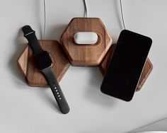 an apple watch and iphone charging station on a white table with two wooden hexagonals