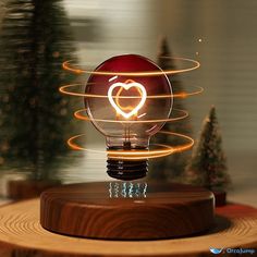 a light bulb with a heart in the middle on top of a wooden table next to christmas trees