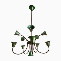 a green chandelier with six lights hanging from it's center and four arms