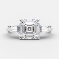 an emerald cut diamond ring with three baguets