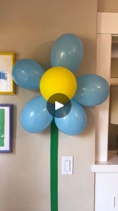 a large balloon flower on the wall in a living room with other balloons and pictures