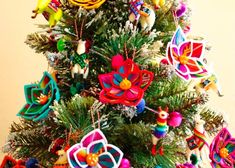 a colorful christmas tree with ornaments on it's branches and decorations hanging from the top