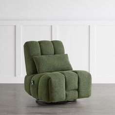 a green recliner chair sitting on top of a hard wood floor next to a white wall