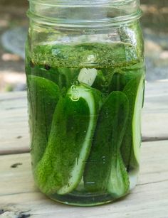 pickles in a mason jar filled with green liquid