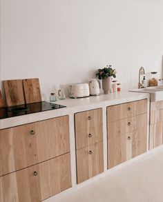 a kitchen with wooden cabinets and white walls