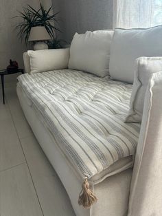 a white couch sitting next to a window in a living room