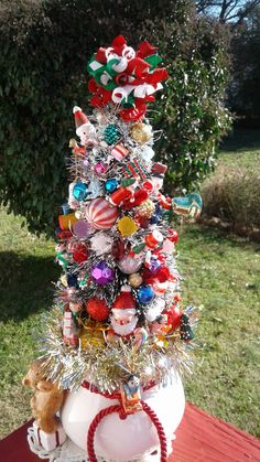 a christmas tree made out of balloons and other ornaments on a table in the yard