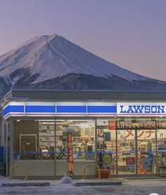 a store front with snow covered mountains in the background