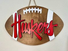 a football shaped sign hanging from the side of a wall