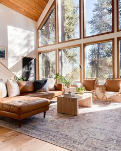 a living room filled with furniture and large windows