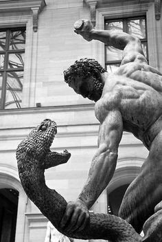 black and white photograph of a statue of a man holding a crocodile