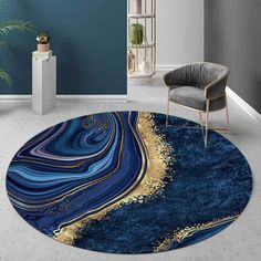 a round rug with blue, gold and white marble design on the floor in a living room