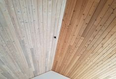 a bed sitting under a wooden ceiling next to a window