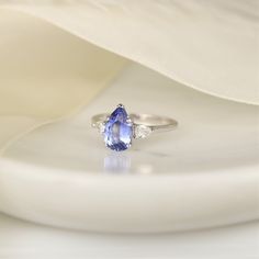 "2cts Ready to Ship Essie 14kt White Gold Cornflower Lavender Sapphire Diamond Minimalist 3 Stone Dainty Pear Engagement Ring,Rosados Box All gemstones used are only premium cut, fairly traded, and/or conflict-free! Our accent diamonds are always natural NEVER treated or enhanced for better color or clarity. For peace of mind, everything within our Rosados Box® line is NEVER simulated or imitation. We only offer stones that are lab grown or natural. Our products are only created with the finest Fine Jewelry Tanzanite Three Stone, Tanzanite Three Stone Wedding Jewelry, Anniversary Three-stone Tanzanite Jewelry, Three Stone Tanzanite Jewelry As Gift, Fine Jewelry Three Stone Teardrop, Trillion Cut Tanzanite White Gold Jewelry, Trillion Cut Tanzanite Jewelry In White Gold, Elegant Tanzanite Trillion Cut Rings, Pear-shaped White Gold Three Stone Jewelry