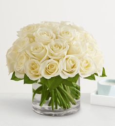 a vase filled with white roses on top of a table