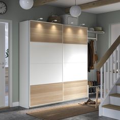 a white and wood closet with stairs leading up to it