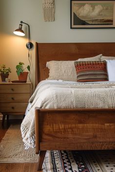 a bedroom with a bed, nightstands and pictures on the wall above it is shown