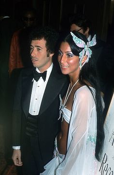 the man and woman are dressed up in formal wear at an event with other people