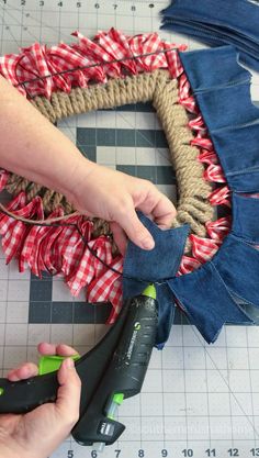 someone is making a wreath out of old jeans and burlocks with some scissors