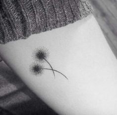 a black and white photo of a dandelion tattoo