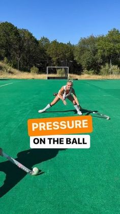 two women playing field hockey on an outdoor court with the words pressure on the ball