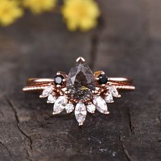 a close up of a ring on a piece of wood with flowers in the background