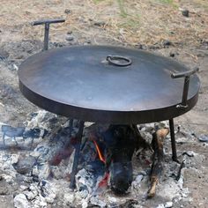 an open fire pit sitting on top of a pile of rocks