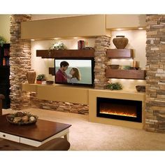 a man and woman standing in front of a flat screen tv mounted on a wall