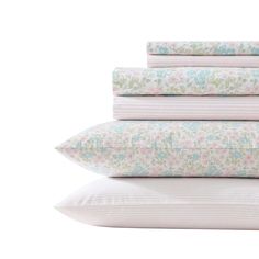 four pillows stacked on top of each other in front of a white background with pink and blue flowers