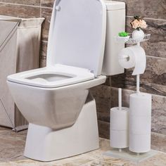 a white toilet sitting in a bathroom next to a roll of toilet paper and a trash can