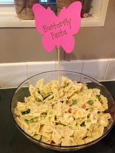 a bowl filled with pasta and topped with a pink butterfly sign that says butterfly pasta