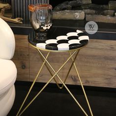 a table with black and white polka dots on it next to a glass filled vase