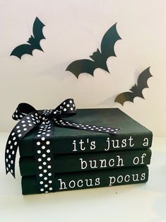 three books with black and white polka dots tied to them, each one has a bat design on it